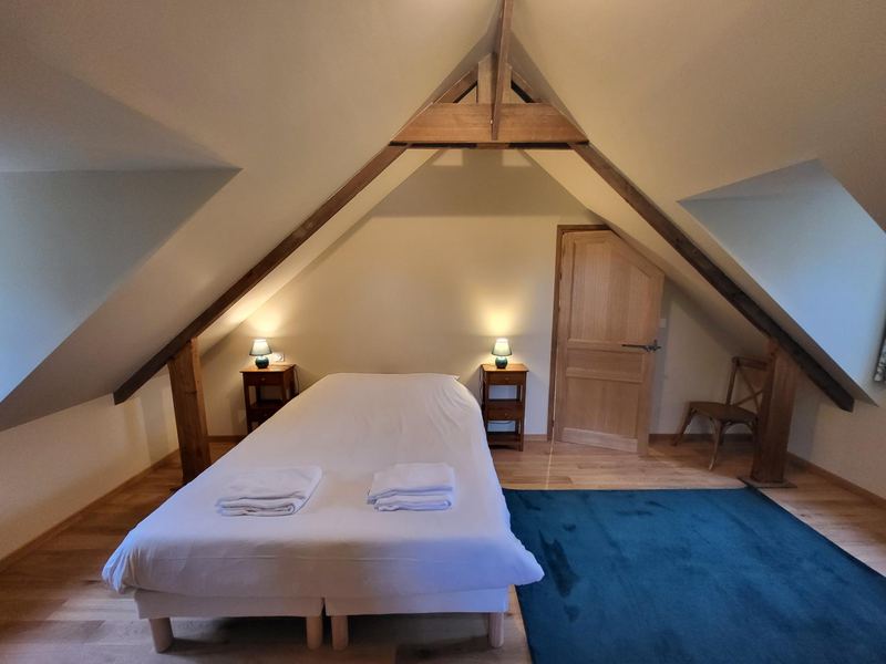 Une chambre double du gîte de l'Étang, sous les poutres