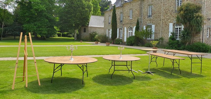 Tables rondes et table d'honneur installées dans la prairie devant la malouinière