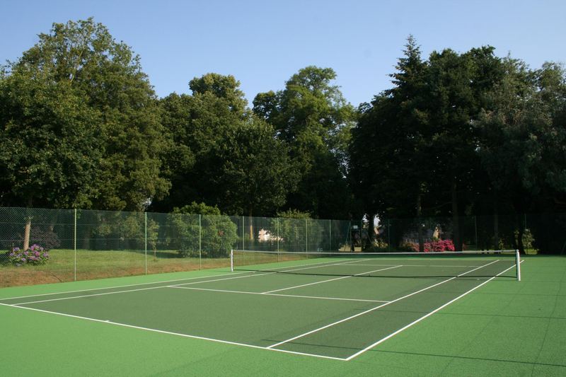 Le court de tennis de la propriété, bordé d'arbres